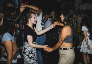 Two women dancing on a dance floor at an LA lesbian event.