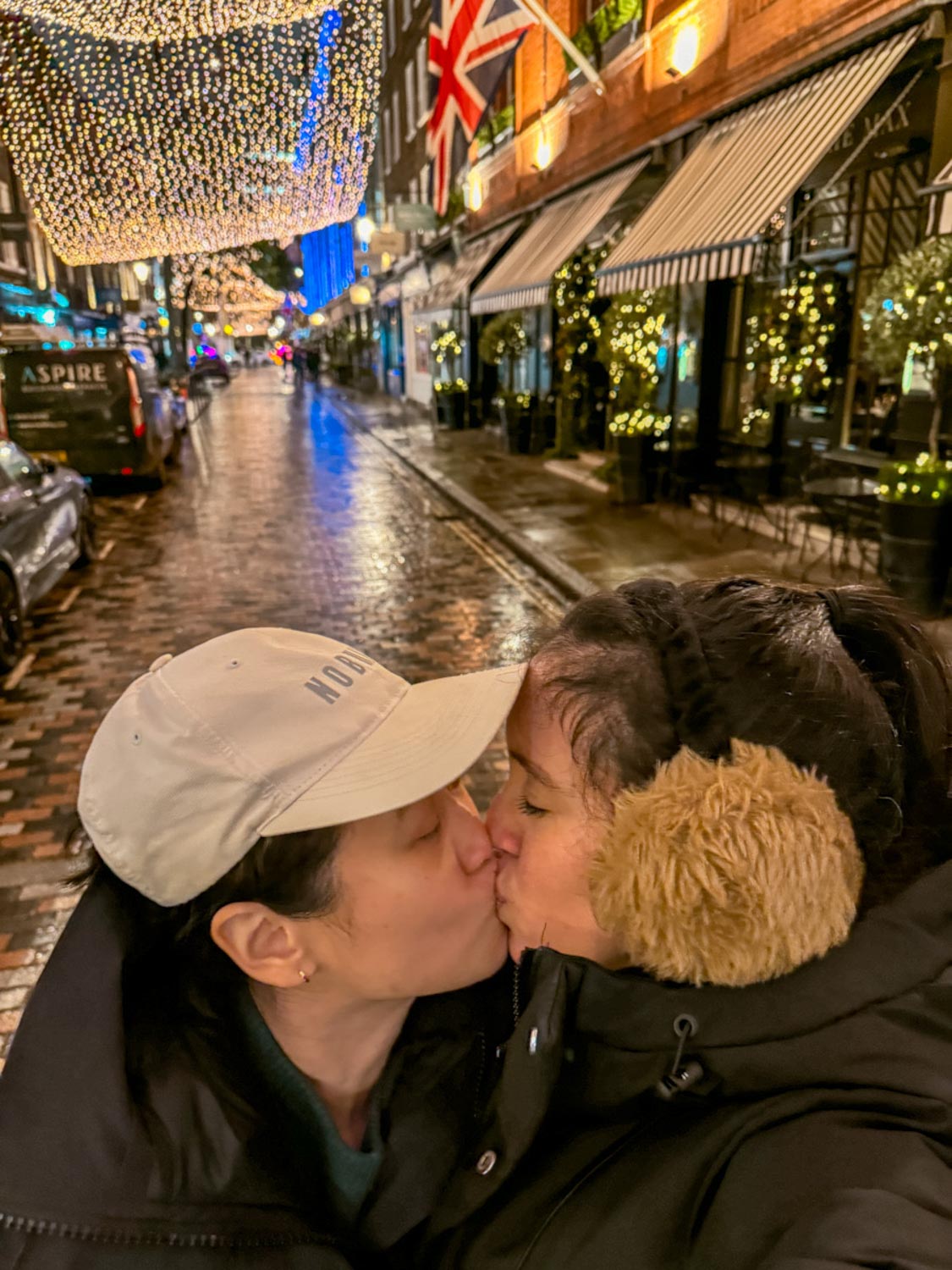 Two women kissing on a street in London, a lesbian travel destination.