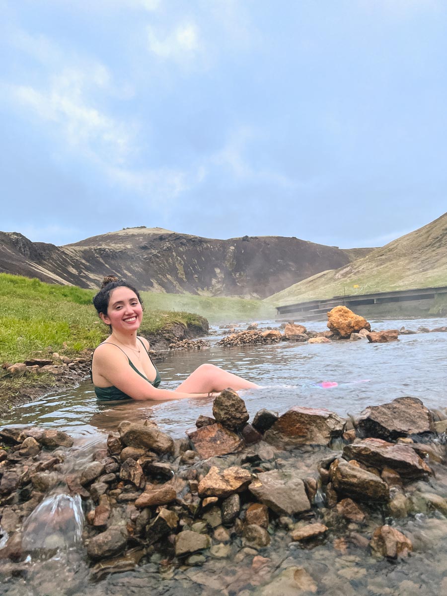 A woman sitting on a natural hot springs in Iceland.