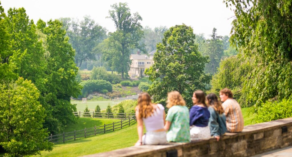 Five students sitting overlooking the hills.